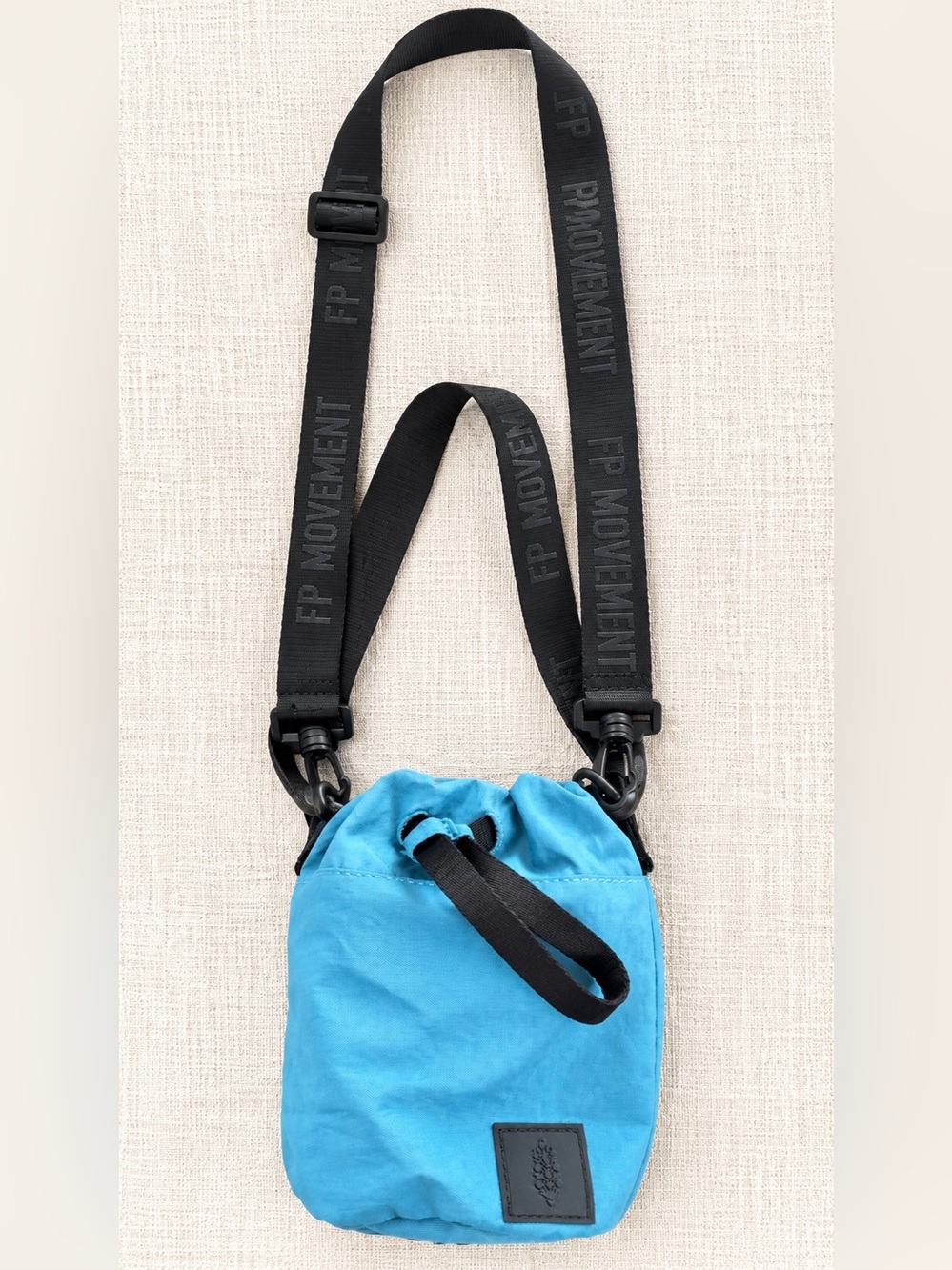 FP Movement blue crossbody pouch with black strap